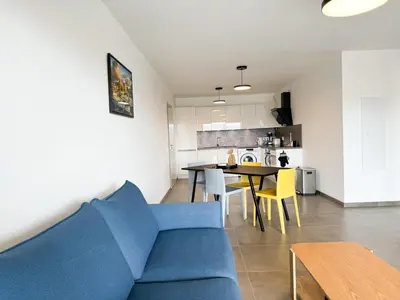 a living room with a blue couch and a table at BEL' ORIZONTE proche centre ville et plage in Propriano