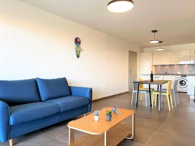 a living room with a blue couch and a table at BEL' ORIZONTE proche centre ville et plage in Propriano