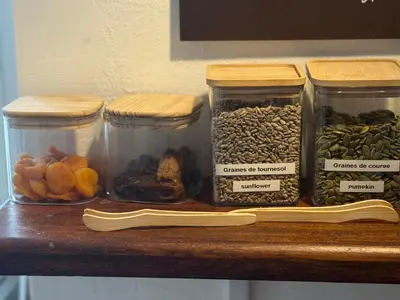 four jars of nuts and dried fruits on a shelf at Hôtel du Nord in Corte