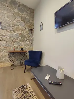 a living room with a table and a blue chair at Studio de 25m2 - Extra centre - À 5 min à pied des plages - Commerces et restaurants sur place - Clim - Wifi - EXCEPTIONNEL in Ajaccio