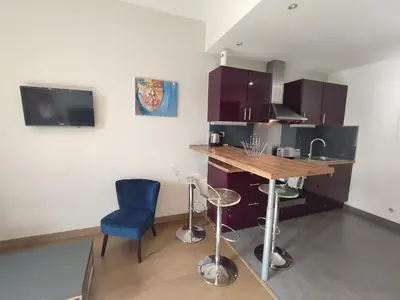 a kitchen with a table and a blue chair at Studio de 25m2 - Extra centre - À 5 min à pied des plages - Commerces et restaurants sur place - Clim - Wifi - EXCEPTIONNEL in Ajaccio