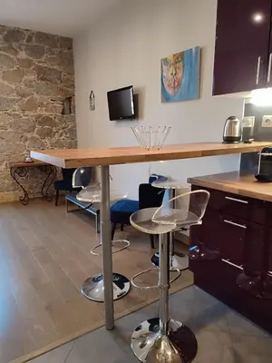 a kitchen with a wooden table and stools at Studio de 25m2 - Extra centre - À 5 min à pied des plages - Commerces et restaurants sur place - Clim - Wifi - EXCEPTIONNEL in Ajaccio