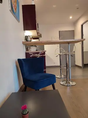 a blue chair sitting in a room with a counter at Studio de 25m2 - Extra centre - À 5 min à pied des plages - Commerces et restaurants sur place - Clim - Wifi - EXCEPTIONNEL in Ajaccio