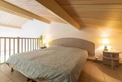 a bedroom with a bed with a wooden ceiling at Bella Vista , à Porticcio, joli appartement vue mer in Grosseto-Prugna