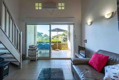 a living room with a couch and a patio with an umbrella at Bella Vista , à Porticcio, joli appartement vue mer in Grosseto-Prugna