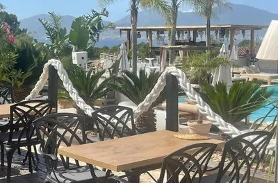 a wooden table and chairs and a table and a pool at Bella Vista , à Porticcio, joli appartement vue mer in Grosseto-Prugna