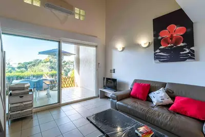 a living room with a couch and a view of a patio at Bella Vista , à Porticcio, joli appartement vue mer in Grosseto-Prugna