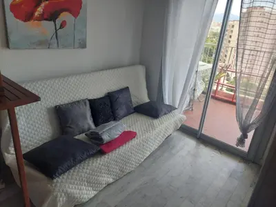 a couch with pillows on it in a living room at AJACCiO VUE MER ET GOLFE in Ajaccio