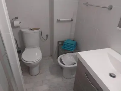 a white bathroom with a toilet and a sink at AJACCiO VUE MER ET GOLFE in Ajaccio