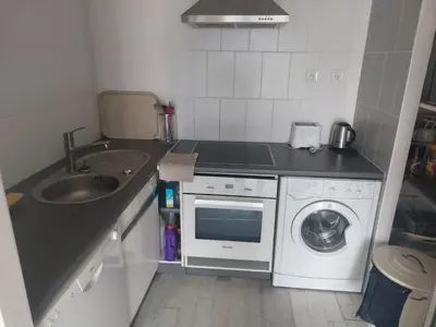 a kitchen with a sink and a washing machine at AJACCiO VUE MER ET GOLFE in Ajaccio
