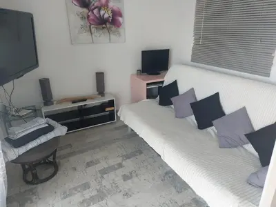 a living room with two white couches and a television at AJACCiO VUE MER ET GOLFE in Ajaccio