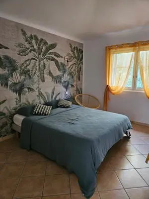 a bedroom with a large bed with a blue blanket at Casa Marcelli 5 in Porto-Vecchio