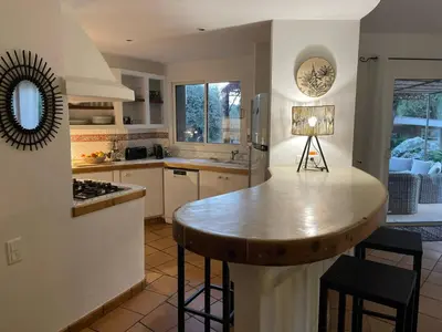 a kitchen with a counter with a table in it at Villa Valentine by Intendance Excellency in Porto-Vecchio