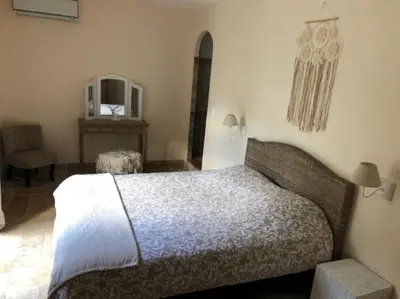 a bedroom with a bed and a table and a chair at Villa Valentine by Intendance Excellency in Porto-Vecchio