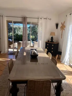a large wooden table with chairs in a living room at Villa Valentine by Intendance Excellency in Porto-Vecchio