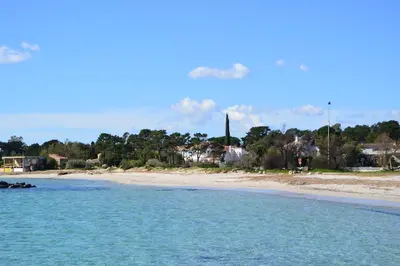 a view of a beach with a town in the background at ST CYPRIEN C18 -4/6 pers- CLIM- à 250m de la plage de sable Saint Cyprien in Lecci