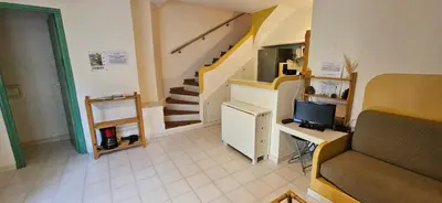 a room with a staircase and a desk with a television at ST CYPRIEN C18 -4/6 pers- CLIM- à 250m de la plage de sable Saint Cyprien in Lecci