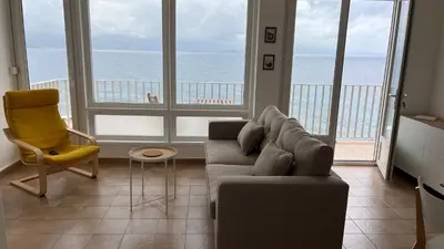 a living room with a couch and a view of the ocean at Le Face à La Mer in Ajaccio