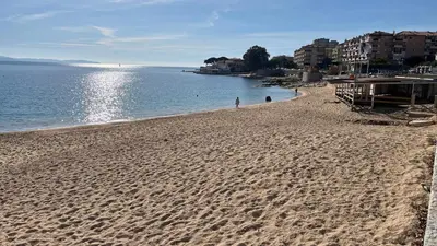a view of a beach with the sun reflecting on the water at Le Face à La Mer in Ajaccio