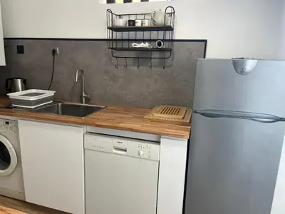 a kitchen with a white refrigerator and a sink at Le Face à La Mer in Ajaccio