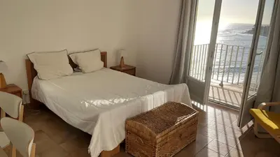 a bedroom with a bed with a view of the ocean at Le Face à La Mer in Ajaccio