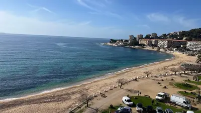 a beach with cars parked on the sand and the water at Le Face à La Mer in Ajaccio