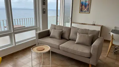 a living room with a couch and a yellow chair at Le Face à La Mer in Ajaccio