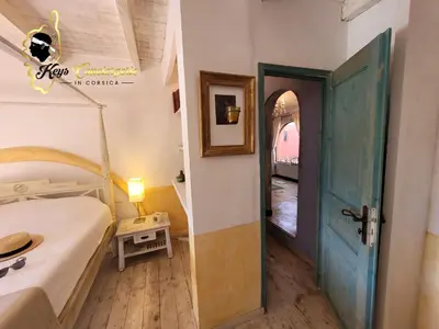 a small bedroom with a bed and a door at Casa Salya 8 pers Piscine privée Chauffée San Cipriano in Lecci