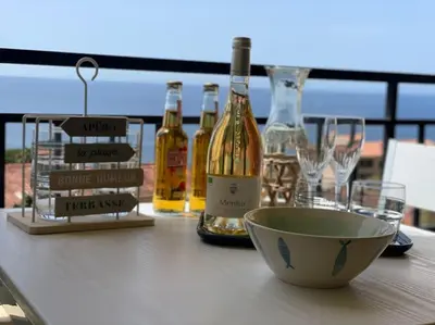 a table with bottles of wine and wine glasses at A Piaghja, refuge romantique face à la mer in Ajaccio