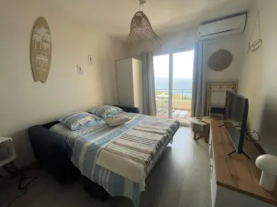 a bedroom with a bed with a view of the ocean at A Piaghja, refuge romantique face à la mer in Ajaccio