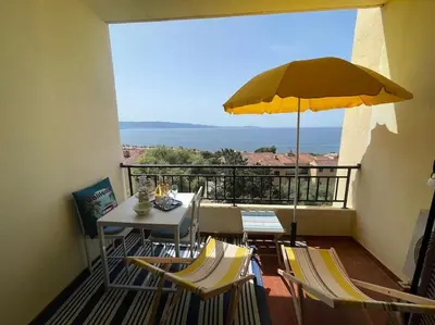a balcony with a table and an umbrella at A Piaghja, refuge romantique face à la mer in Ajaccio