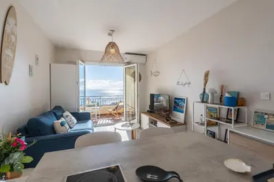a kitchen and living room with a view of the ocean at A Piaghja, refuge romantique face à la mer in Ajaccio