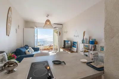 a kitchen and living room with a view of the ocean at A Piaghja, refuge romantique face à la mer in Ajaccio