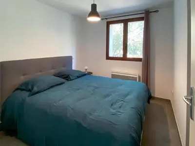 a bedroom with a blue bed with a window at Villa Colombo in Bonifacio