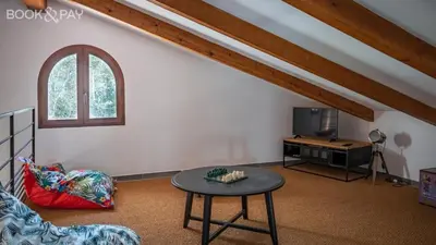 a living room with a table and a tv at Villa Colombo in Bonifacio