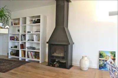 a fireplace in a living room with white book shelves at Villa Roccu in Borgo
