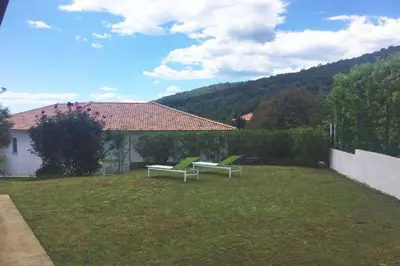 two green chairs sitting in a yard with a house at Villa Roccu in Borgo