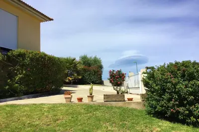 a park with a bench and plants and a building at Villa Roccu in Borgo