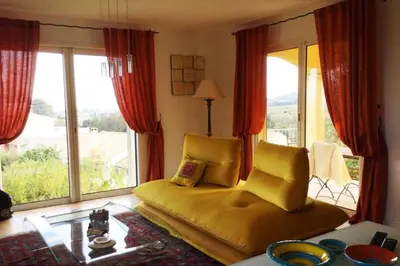 a living room with a couch and a large window at Villa Roccu in Borgo