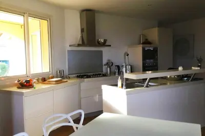 a kitchen with white cabinets and a stove top oven at Villa Roccu in Borgo