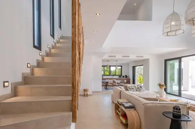 a living room with stairs and a couch at Villa Bambou 12 pers piscine chauffée 10 minutes à pieds plage in Sainte-Lucie de Porto-Vecchio
