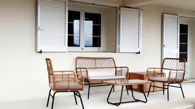 a group of rattan chairs and a table and a window at Studio Venaco Centre Corse in Venaco
