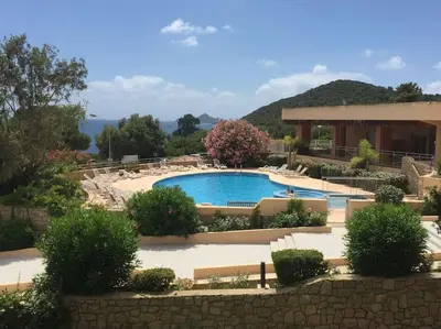 a swimming pool in a yard with a building at F2 vue mer dans résidence avec piscine in Ajaccio
