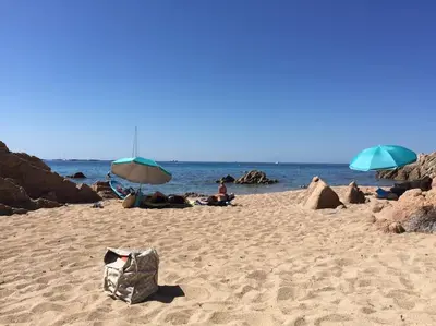 a group of people laying on a beach with umbrellas at F2 vue mer dans résidence avec piscine in Ajaccio