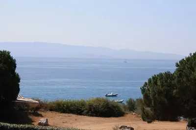 a boat in the water on a beach at F2 vue mer dans résidence avec piscine in Ajaccio