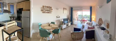 a kitchen and a living room with a table and chairs at F2 vue mer dans résidence avec piscine in Ajaccio