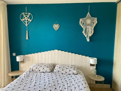 a bedroom with a blue wall with a bed and decorations at F2 vue mer dans résidence avec piscine in Ajaccio
