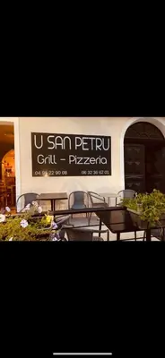 a sign on a building with tables in front of it at Chambre avec balcon à louer in Bains de Guitera