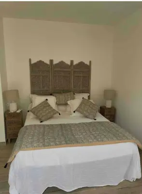 a bedroom with a large white bed with pillows at Chambre avec balcon à louer in Bains de Guitera
