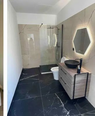 a bathroom with a sink and a shower and a toilet at Chambre avec balcon à louer in Bains de Guitera